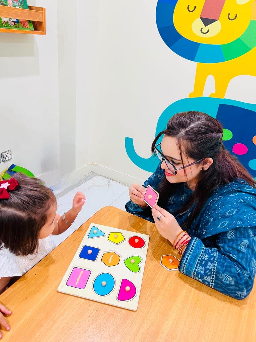 Child practicing skills with positive reinforcement during an ABA therapy session at NEST, Islamabad